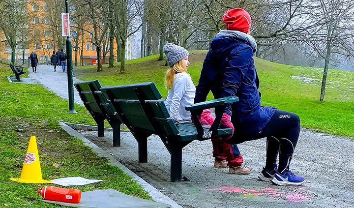 Familjefys vid en parkbänk